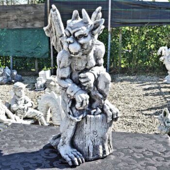 Gargoyle zittend op boomstam tuinbeeld